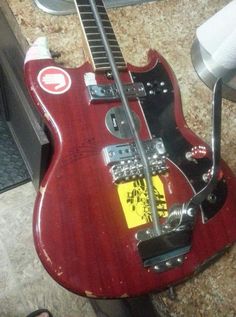 a red electric guitar sitting on top of a counter