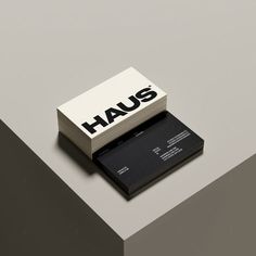 a black and white business card holder on top of a gray surface with the word haus printed on it