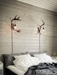 a bed with two antlers on the wall above it