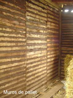 hay bales are stacked in the corner of a room that is made out of wood