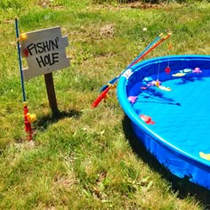 an empty swimming pool in the grass with a sign that says fishin'hole