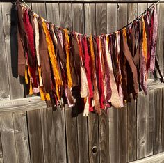 a multicolored cloth hanging on a wooden fence