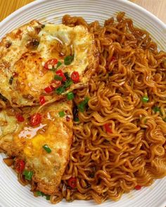 a white plate topped with noodles and meat