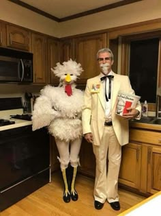 two people dressed up as chicken and man in white suit standing next to each other