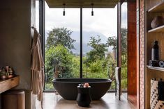 a large bath tub sitting in the middle of a bathroom next to a wooden shelf