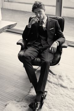 a man in a suit is sitting on a chair