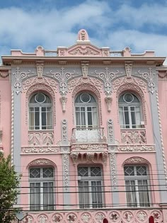 an old pink building with ornate carvings on it