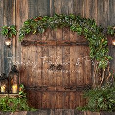 an old wooden door decorated with greenery and candles