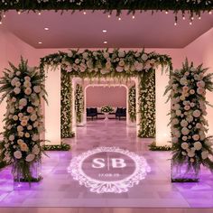 the entrance to a wedding venue decorated with flowers and greenery for an elegant ceremony