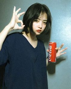 a woman with her hands in the air and a can of coca - cola on her shoulder