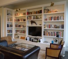 a living room filled with lots of furniture and bookshelves next to a flat screen tv