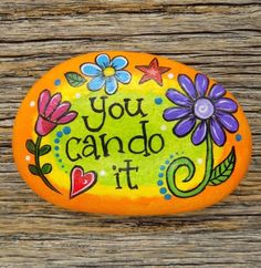 an orange painted rock that says you can do it with flowers and hearts on it