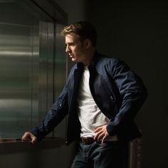 a man in a suit and tie leaning against a wall