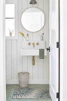 a bathroom with a sink, mirror and rug