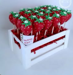 strawberries are arranged on top of each other in a white box with red and green sprinkles