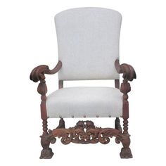 a white chair with wooden carvings on the armrests and back rest, against a white background