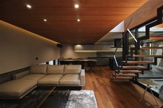 a modern living room with wood floors and stairs