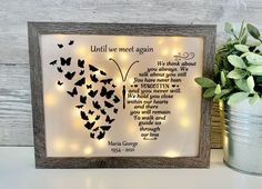 a light up frame with butterflies on it and a potted plant next to it