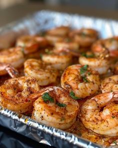 cooked shrimp with parsley and seasoning in a metal pan on top of a stove