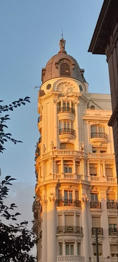 a tall building with many windows and balconies on it's sides at sunset