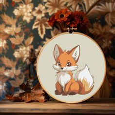 a cross stitch fox sitting on top of a wooden table