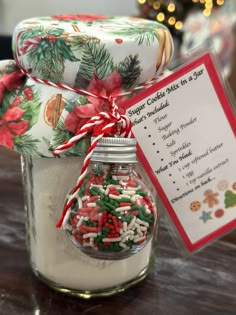 a jar filled with candy canes next to a christmas ornament