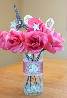 pink flowers in a vase with the eiffel tower in the background on a table