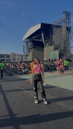 a woman standing in front of a stage with lots of people on it's sides