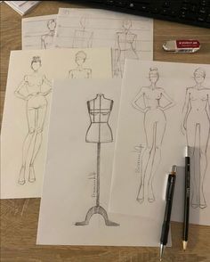 three drawings of female mannequins on top of a desk next to a keyboard