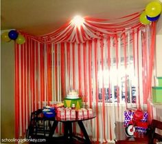 a room with red and white striped curtains on the wall, balloons in the air