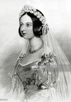 an old black and white photo of a woman wearing a wedding dress with a veil on her head