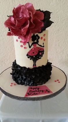 a white and black cake with pink flowers on top