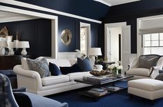 a living room with blue walls and white furniture