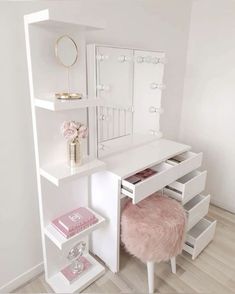 a white desk with drawers and a mirror on it's wall next to a pink stool