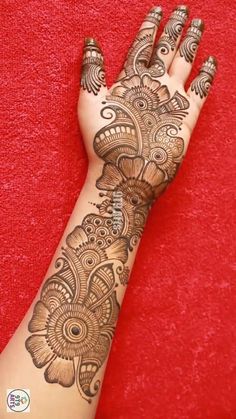 a woman's hand with henna tattoos on it