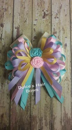 a hair bow that is on top of a wooden surface with the words duke's hair bows written below it