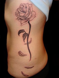 a woman's stomach with a rose tattoo on it