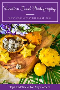 a wooden bowl filled with fruit and flowers on top of a table next to lemons