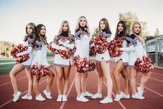 a group of cheerleaders standing on top of a track