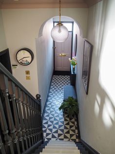 an image of a hallway with black and white floor tiles on the walls, and stairs