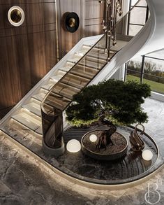 an indoor staircase leading up to a tree in the middle of a room with stairs and chandelier