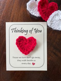 two crocheted hearts sitting on top of a card