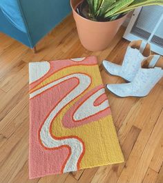 a pair of shoes sitting on top of a wooden floor next to a rug