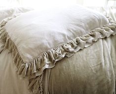 a white pillow with ruffled edges on a bed