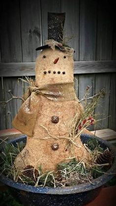 a snowman made out of hay in a planter