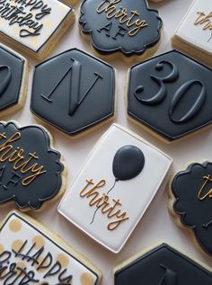 decorated cookies with black and white icing are arranged on a table in the shape of hexagons