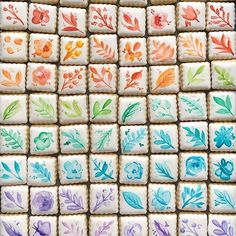 many decorated cookies with flowers and leaves are arranged in the shape of square tiles on top of each other