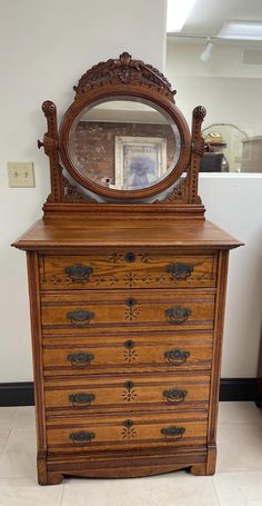 an old wooden dresser with a mirror on top