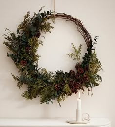 a wreath hanging on the wall next to a candle