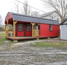 a small red and yellow house sitting on top of a grass covered field